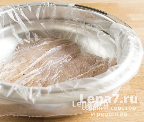 Обработанные кусочки мяса в миске под пищевой пленкой
