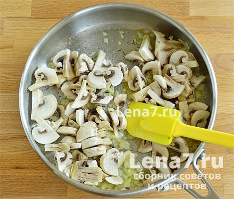 Перемешанные со специями грибы и лук в сковороде