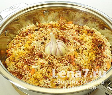 Рис, распределенный по сковороде; добавленные специи и чеснок