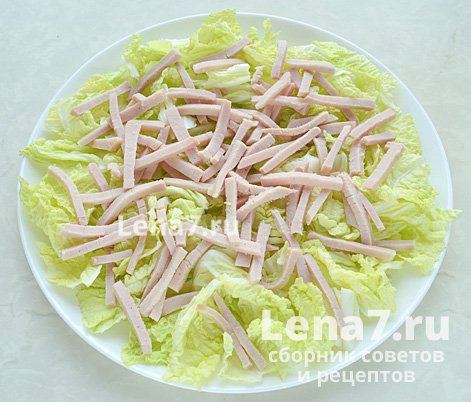 Нарезанный карбонад, выложенный на тарелку, поверх листьев салата
