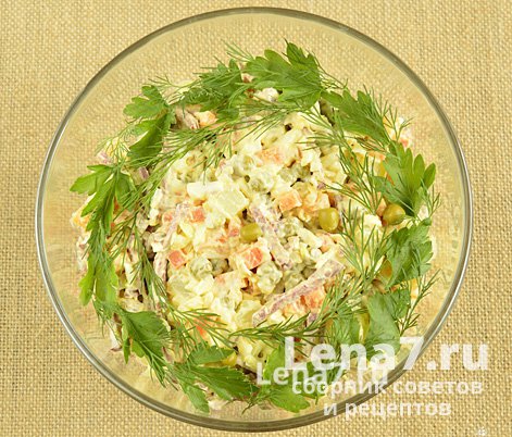 Готовый салат в салатнице, украшенный зеленью