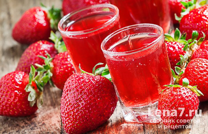 Клубничный напиток красного цвета с лежащими рядом ягодами